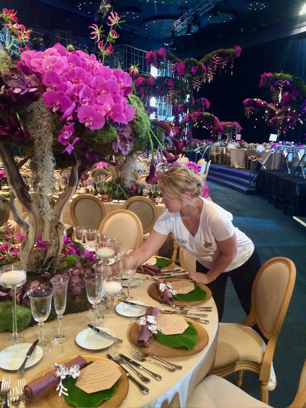 Fleuriste installant un décor floral dans une salle de réception